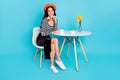 Full body photo of young attractive girl happy positive smile sit table cafe isolated over blue color background Royalty Free Stock Photo