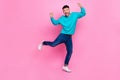Full body photo of young attractive male raise fists celebrate luck excited wear trendy blue clothes isolated on pink