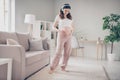 Full body photo of young attractive pregnant woman happy positive smile enjoy listen music earphones hands on belly home Royalty Free Stock Photo