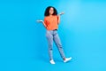 Full body photo of young cheerful african woman happy positive smile hesitate doubt think isolated over blue color