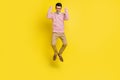 Full body photo of young excited man happy positive smile excited rejoice win victory jump up isolated over yellow color