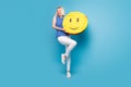 Full body photo of young girl happy positive hold paper pinata emoji smile look empty space isolated over blue color