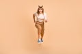 Full body photo of young girl happy positive smile jump up go run hurry sale isolated over beige color background