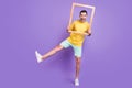 Full body photo of young man happy positive smile hold wooden frame make picture isolated over violet color background Royalty Free Stock Photo