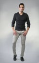 Full body photo of young man standing on grey background Royalty Free Stock Photo