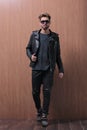 A man is standing in a black leather jacket and jeans Royalty Free Stock Photo