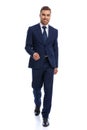 full body picture of happy young businessman in navy blue suit walking Royalty Free Stock Photo