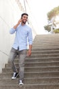 Full body arabic man walking downstairs and talking on mobile phone Royalty Free Stock Photo