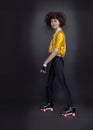 Full body portrait of asian funky girl ride on roller skates keeping balance on studio isolated background retro vintage quad