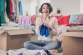 Full body portrait of astonished pretty person hands hold footwear sit on floor carpet near carton boxes indoors Royalty Free Stock Photo