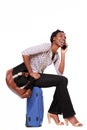 Full body woman sitting on suitcase having phone conversation Royalty Free Stock Photo