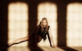 Blond female sits on a floor in a shadow. Royalty Free Stock Photo