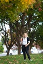 A full body portrait of Caucasian woman with long blond hair wearing casual outfit on fall foliage background Royalty Free Stock Photo