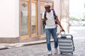 Full body happy african american tourist walking with suitcase and mobile phone Royalty Free Stock Photo