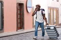 Full body happy african american tourist walking with suitcase and talking on mobile phone Royalty Free Stock Photo