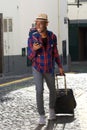 Full body happy african american travel man walking with bags and cellphone on street Royalty Free Stock Photo