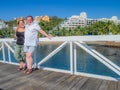 Full body portrait of a happy elderly couple smiling on a pedestrian bridge against beach resorts Royalty Free Stock Photo