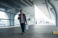 Full body portrait of a happy male traveler walking with bags and coffee Royalty Free Stock Photo