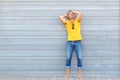 happy man posing with hands behind head against gray wall Royalty Free Stock Photo