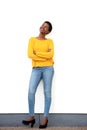 Full body happy young african american woman standing against white wall and looking up Royalty Free Stock Photo