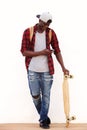 Full body happy young man with skateboard looking at cell phone and smiling Royalty Free Stock Photo