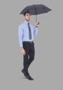 Full body portrait of man holding umbrella standing with grey background Royalty Free Stock Photo