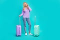 Full body portrait of nice cheerful lady speak communicate telephone airport suitcase isolated on turquoise color