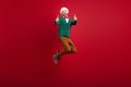 Full body portrait of overjoyed crazy guy jumping hands fingers show thumb up feedback isolated on red color background Royalty Free Stock Photo