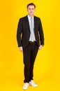 Full body portrait photo of handsome and executive look caucasian businessman in black suit pose in boss action and positive smile Royalty Free Stock Photo