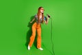 Full body portrait of pretty young girl sing mic empty space wear top isolated on bright green color background Royalty Free Stock Photo