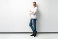 Full body portrait of relaxed mature man standing with arms crossed over white background. Royalty Free Stock Photo