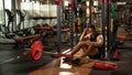 Full body portrait of tired sporty male after workouts on power exercise machine in a gym club Royalty Free Stock Photo