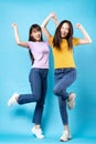 Full body portrait of two beautiful young asian girls on a blue background Royalty Free Stock Photo