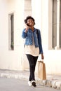 African woman walking on the street with shopping bags and mobile phone Royalty Free Stock Photo