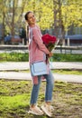 Portrait of a young beautiful woman with a bouquet of red roses in spring park Royalty Free Stock Photo