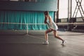 Full body portrait of young girl tennis player in action in a tennis court indoor Royalty Free Stock Photo