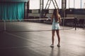 Full body portrait of young girl tennis player in action in a tennis court indoor Royalty Free Stock Photo