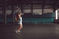 Full body portrait of young girl tennis player in action in a tennis court indoor Royalty Free Stock Photo