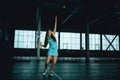 Full body portrait of young girl tennis player in action in a tennis court indoor Royalty Free Stock Photo