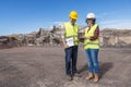 Cheerful construction specialists with tablet discussing plans on industrial area Royalty Free Stock Photo