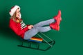 Full body profile photo of funky santa young lady slide wear sweater jeans boots isolated on green background Royalty Free Stock Photo