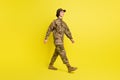 Full body profile photo of pretty satisfied lady walking look empty space  on yellow color background Royalty Free Stock Photo