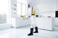 Full body profile side photo of focused guy cleaner in coverall spray sprayer window kitchen whitre surface prevent