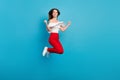 Full body profile side photo of young girl happy positive smile rejoice victory jump over blue color background