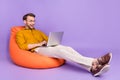 Full body profile side photo of young man happy positive smile work laptop programmer  over purple color Royalty Free Stock Photo