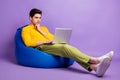 Full body profile side photo of young man serious think look laptop programmer sit chair bean  over violet color Royalty Free Stock Photo