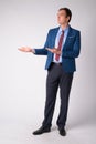 Full body shot of businessman in suit thinking while showing something Royalty Free Stock Photo