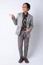 Full body shot of happy Japanese businessman pointing and looking to side Royalty Free Stock Photo