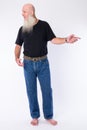 Full body shot of happy mature bald bearded man pointing finger and looking away Royalty Free Stock Photo