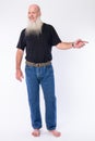 Full body shot of happy mature bald bearded man pointing to the side Royalty Free Stock Photo